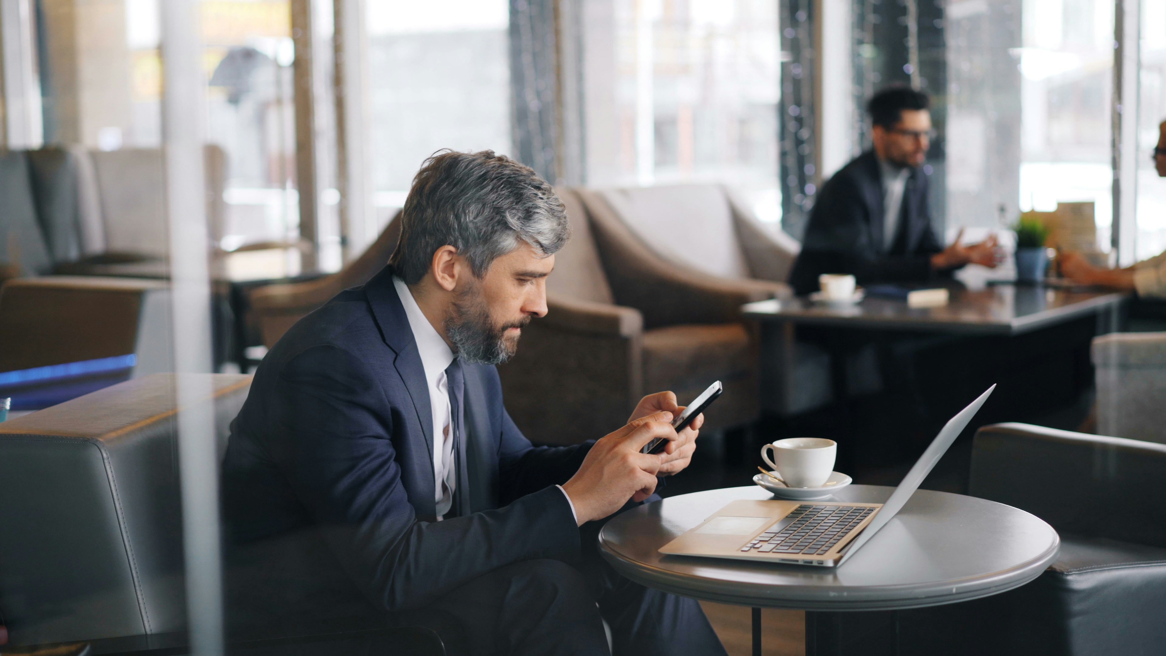 A person checking payout notifications on the HostHub app while holding a phone on a city street